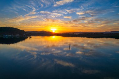Brisbane Suları üzerindeki bulutlu hava gündoğumu manzarası. Woy Woy 'daki Merkez Sahili, NSW, Avustralya..