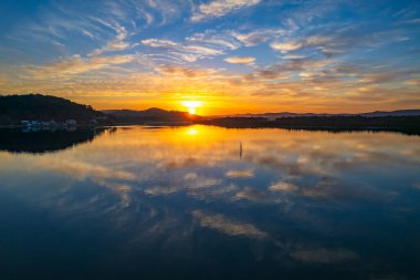 Brisbane Suları üzerindeki bulutlu hava gündoğumu manzarası. Woy Woy 'daki Merkez Sahili, NSW, Avustralya..