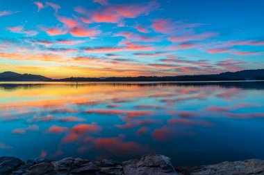 Brisbane Suları 'nın üzerindeki bulutlarla gün doğumu suları Orta Sahilde Woy Woy' da, NSW, Avustralya.