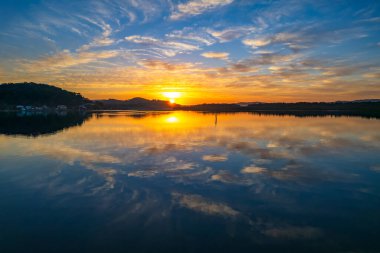 Brisbane Suları üzerindeki bulutlu hava gündoğumu manzarası. Woy Woy 'daki Merkez Sahili, NSW, Avustralya..