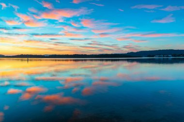 Brisbane Suları 'nın üzerindeki bulutlarla gün doğumu suları Orta Sahilde Woy Woy' da, NSW, Avustralya.