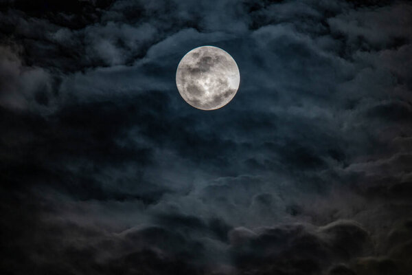 The full moon and cloud cover drifting in the night sky over Woy Woy on the Central Coast of NSW, Australia.