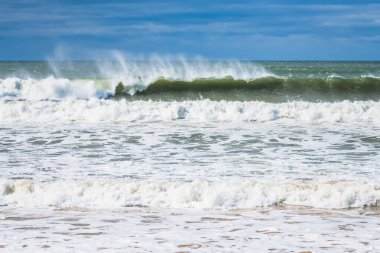 Central Coast, NSW, Avustralya 'daki Umina Sahili' nde rüzgarlı bulutlu bir günde dev bir sörf..