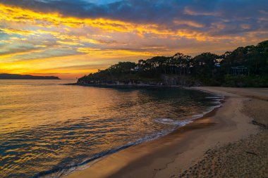 Sahil kenarında gün doğumu bulutlu gökyüzü Pearl Beach 'ten Central Coast, NSW, Avustralya.