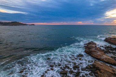 Gün doğumu deniz manzarası, Avoca Sahili 'nde dalgalar ve bulutlar ile Orta Sahilde NSW, Avustralya.
