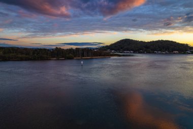 Orta ve yüksek bulut örtüsü karışımlı hava gündoğumu su manzarası Orta Sahilde, NSW, Avustralya 'da Woy Woy körfezindeki suya yansıyor.