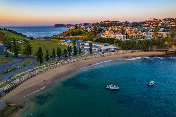 NSW, Avustralya 'nın merkez kıyısındaki Terrigal kıyı banliyösüne bakan teknelerle açık hava güneşinin doğduğu deniz manzarası..