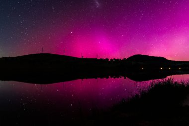Güney Işıkları - Aurora Australis ve gece gökyüzü Orta Batı, NSW, Avustralya 'daki Carcoar Barajı' nda pembe çizgilerle doluydu..