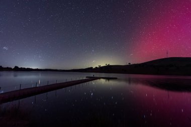 Güney Işıkları - Aurora Australis ve gece gökyüzü Orta Batı, NSW, Avustralya 'daki Carcoar Barajı' nda pembe çizgilerle doluydu..