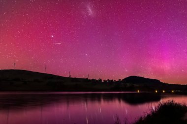 Güney Işıkları - Aurora Australis ve gece gökyüzü Orta Batı, NSW, Avustralya 'daki Carcoar Barajı' nda pembe çizgilerle doluydu..