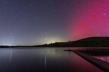 Güney Işıkları - Aurora Australis ve gece gökyüzü Orta Batı, NSW, Avustralya 'daki Carcoar Barajı' nda pembe çizgilerle doluydu..