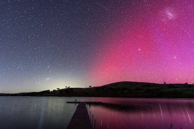 Güney Işıkları - Aurora Australis ve gece gökyüzü Orta Batı, NSW, Avustralya 'daki Carcoar Barajı' nda pembe çizgilerle doluydu..