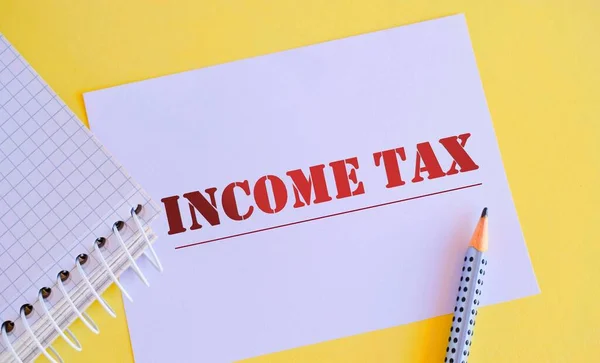 White paper with text income tax.Conceptual photo colloquial term for time on which individual income tax returns.
