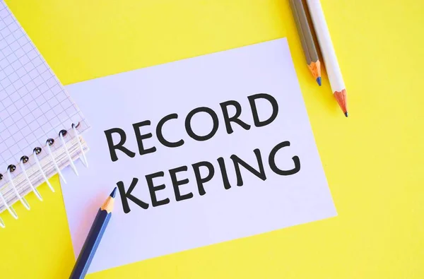 Record keeping text written on a white paper with pencils. Conceptual photo The activity or occupation of keeping records or accounts