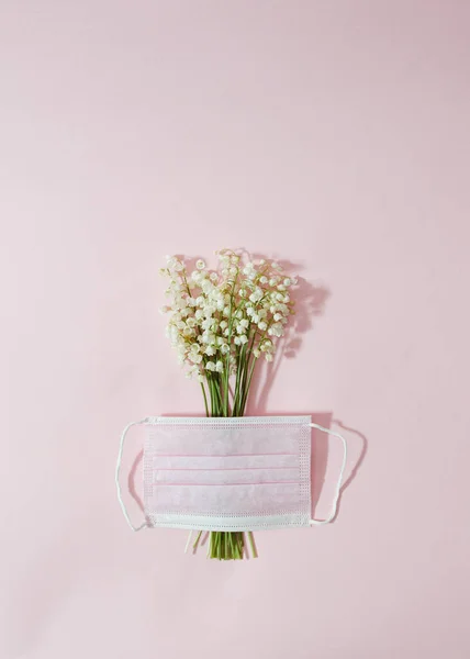 Vadinin zambakları açık pembe koruyucu bir maskeyle kısmen kaplıdır. Bahar salgını konsepti çok az. Pastel pembe arkaplan.