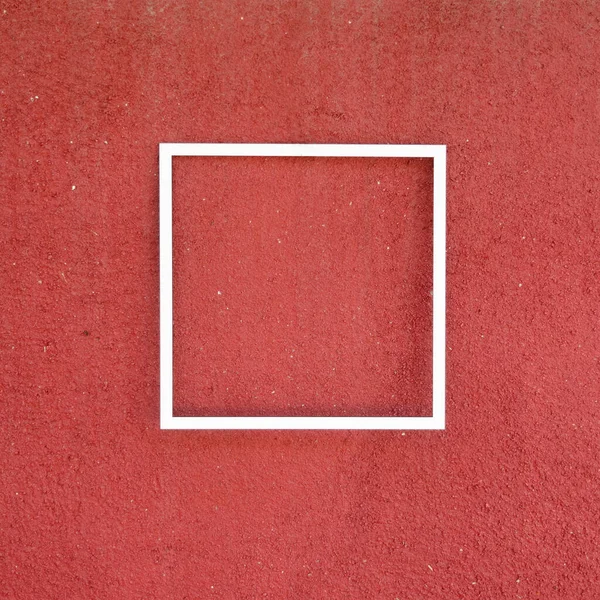 A white frame on a terracotta wall. Minimal summer card or invitation concept. Trendy immaculate design.