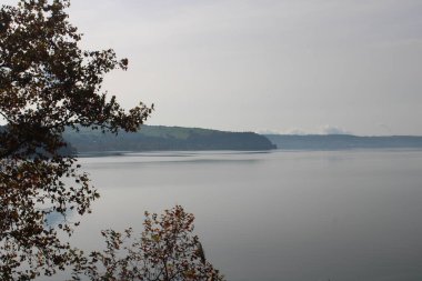 Göl manzaralı kadın ve göl kenarındaki dağlar sonbahar gölü bracciano 'da Roma yakınlarında.