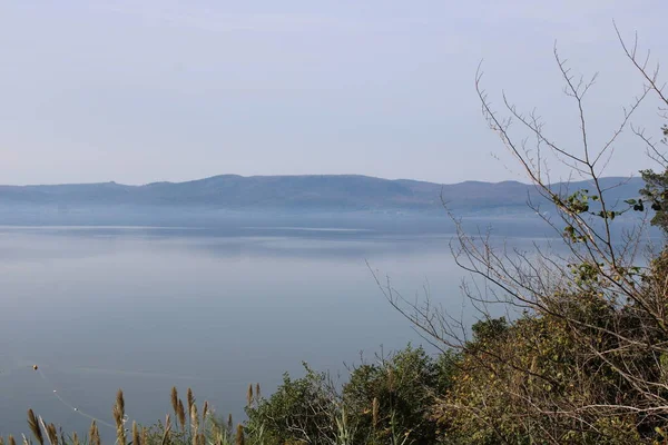 Göl manzaralı kadın ve göl kenarındaki dağlar sonbahar gölü bracciano 'da Roma yakınlarında.