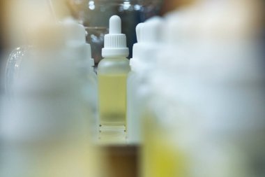 Küçük cam bir şişenin ucundaki şişede sıvı var..