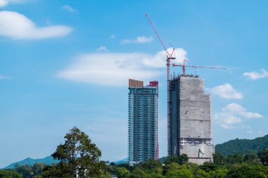 Ağaçların, dağların, doğanın ve güzel gökyüzünün ortasında uzun binalar inşa ediliyor..