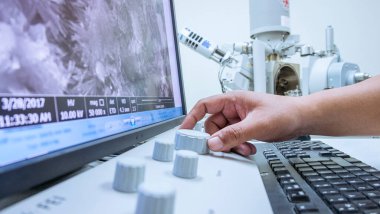 Büyütme eli, laboratuardaki monitörlü bir makine gibi yüksek büyütme kamerasını kontrol eder..