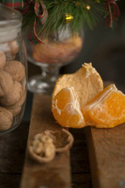 Yeni yıl mandalinaları, kavanozda cevizler, sandalyesinde oyuncak ve fiyonklar olan bir sürü Noel ağacı.