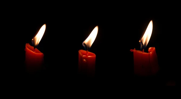 Luz de tres velas aislada en negro — Foto de Stock