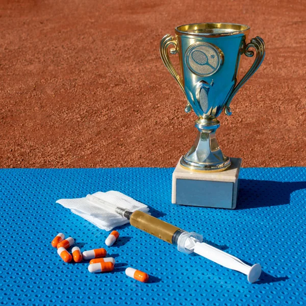 Trophy cup, medicines and syringe with platelet-rich plasma. Sports medicine and rehabilitation. High achievement and recovery concept. Square size. Copy space