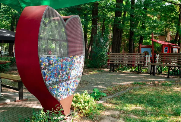 Heart-shaped waste collection bin in city park, Plovdiv, Bulgaria. Environmental protection, waste management concept. Plastic reuse for recycling