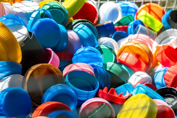 Plastic waste collection background. Multicolored single use plastic bottle caps are collection for recycling. Recycling plastic, ecology, waste management, environmental protection concept.