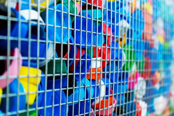 Disposable single - use plastic bottle caps collected for recycling. Ecology, environmental protection concept. Plastic waste background. Selective focus.