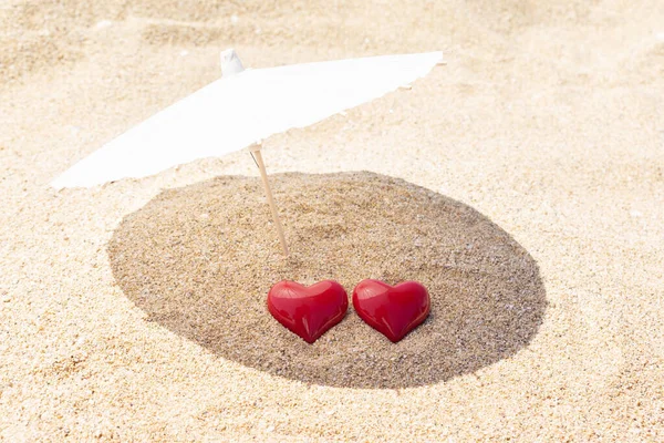 Zwei Rote Herzen Unter Einem Sonnenschirm Auf Goldenem Sand Valentinstag — Stockfoto
