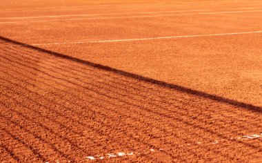 Clay tennis court with a net shadow on it. Season of the game on the open red clay tennis court. Orange. Background, texture, space for text. clipart