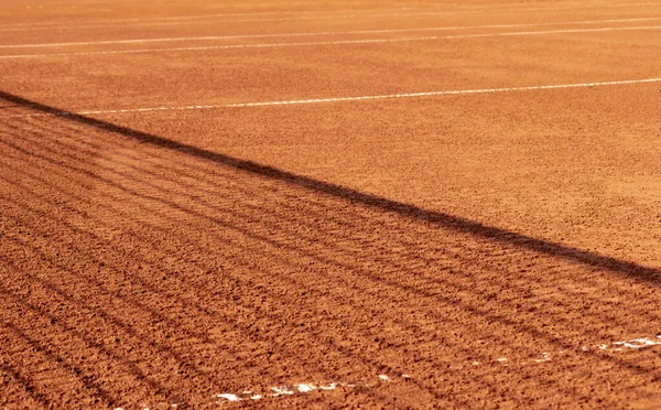 Üzerinde ağ gölgesi olan kil tenis kortu. Maçın sezonu açık kırmızı kil tenis kortunda. Turuncu. Metin için arkaplan, doku, boşluk.