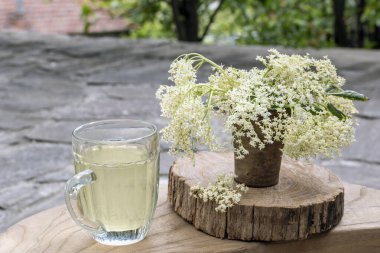 Sambucus limonatası ve ahşap masada mürver çiçekleri. Taze elderberry - Sambucus nigra şurubu. Ev yapımı yaşlı çiçek içeceği. Sağlıklı doğal yiyecek ve içecek konsepti. Taşra yaşam tarzı. Boşluğu kopyala