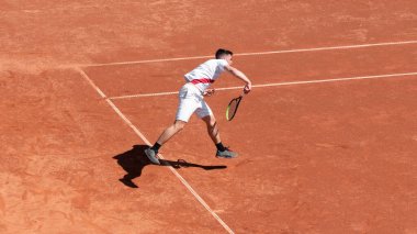 Tenis oyuncusu maç boyunca kil tenis kortunda hareket halinde. Profesyonel sporcuların cesareti. Bireysel spor