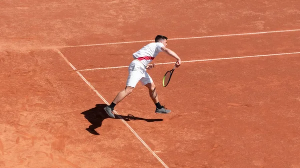 Tenis oyuncusu maç boyunca kil tenis kortunda hareket halinde. Profesyonel sporcuların cesareti. Bireysel spor