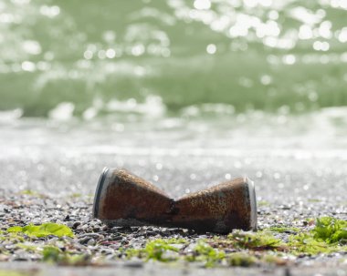 Metal atıklarla dolu deniz kirliliği. Deniz kıyısındaki paslı alüminyum kutu dalga tarafından atıldı. Çöp, çöp, su kirleten doğa ve Dünya okyanusu. Geri dönüşüm, yeniden alüminyum kullanımı. Kare arkaplan, kopyalama alanı