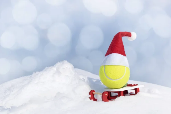 Christmas Creative Composition Yellow Tennis Ball Red Santa Hat Sleigh — Stock Photo, Image