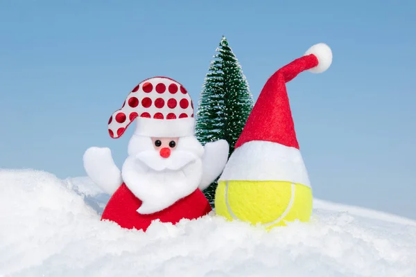 Noel Baba, Noel ağacı ve kış günü kar yağdığında kırmızı Noel Baba şapkalı tenis topu. Mutlu Noeller ve mutlu yıllar tebrik kartı, yaratıcı noel kompozisyonu