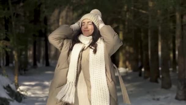 Meisje model poseren in de zon in een besneeuwd bos. — Stockvideo