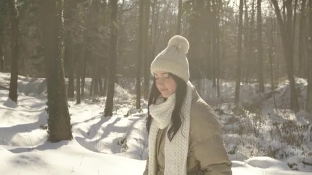 Bella e giovane ragazza passeggiate e sorrisi nella foresta invernale — Video Stock