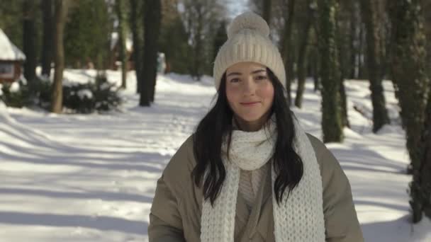 Vista frontale. Bella e giovane ragazza passeggiate e sorrisi nella foresta invernale — Video Stock