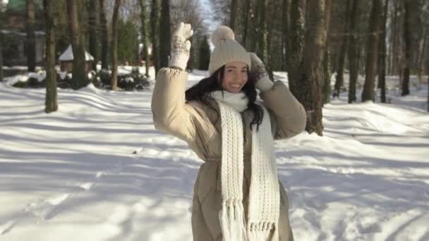 Vista posteriore. Bella e giovane ragazza passeggiate e sorrisi nella foresta invernale. — Video Stock