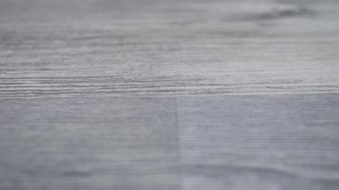 Gri ahşap yüzen zemin görüntüleri. Kamera ahşap zemin boyunca kayar. Soldan sağa hareket eder..