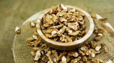 Yuvarlak ahşap bir kasede soyulmuş ceviz. Siyah arka plan..