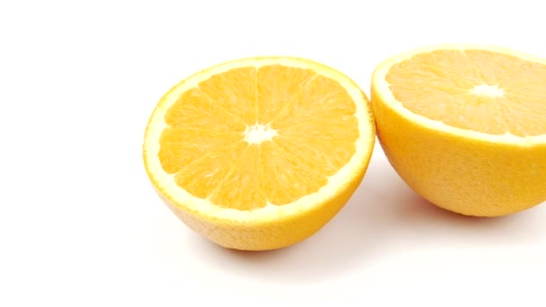 白の背景に隔離された2つのオレンジのクローズアップ 健康食品の概念 健康的な生活のための映像 オレンジのスライスを回転させ — ストック動画