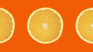 Sarı arka planda olgun sulu portakal diliminin dönen görüntüsü. 4K canlandırması.