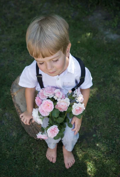 Lindo Niño Tímido Sentado Jardín Con Gran Ramo Rosas Rosadas — Foto de Stock