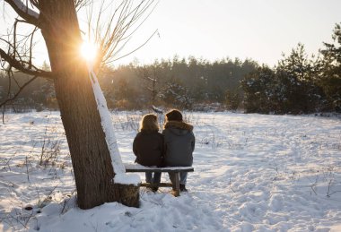 Genç bir kadın ve bir adam sırtı kapalı bir yerde bir bankta oturuyor, birbirlerinin ve kış günbatımının keyfini çıkarıyorlar. İyi bir ilişki, aşık olmak, romantizm, hassas duygular.